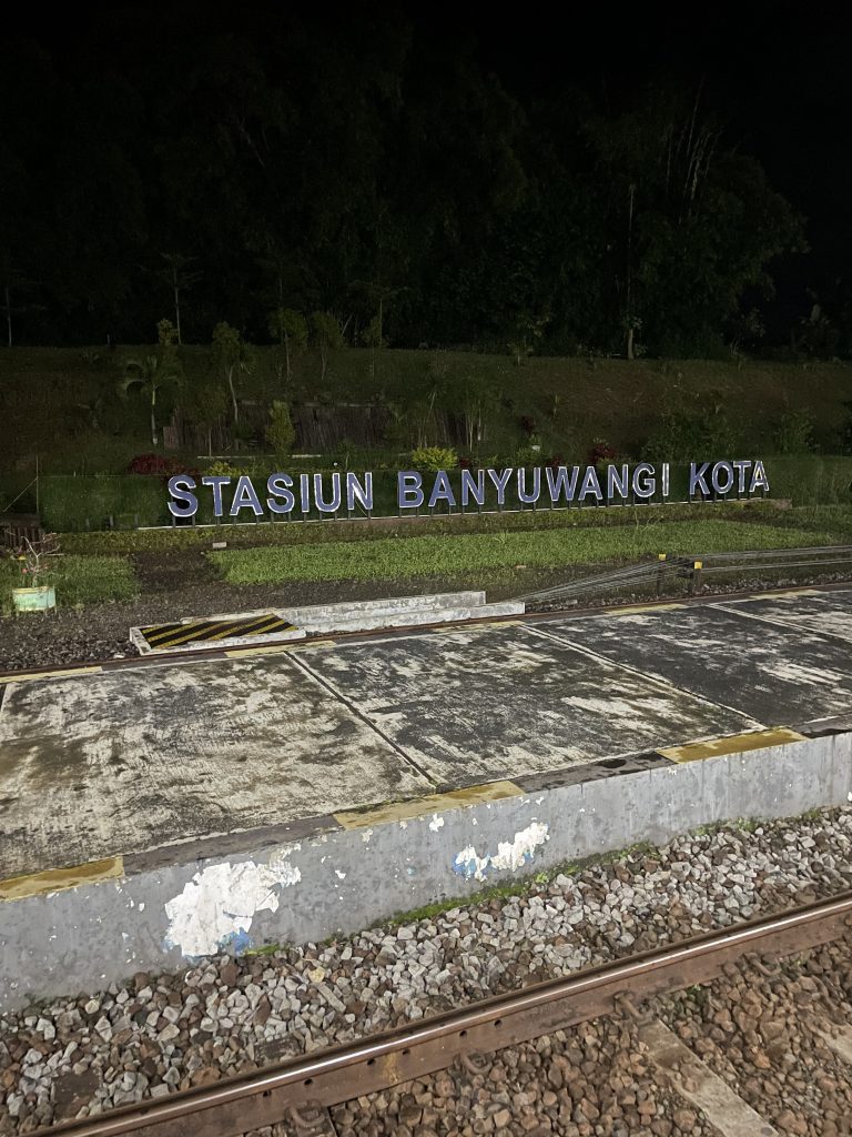 The Stasiun Banyuwangi Kota station sign lit up at night